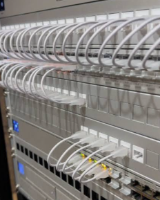 A UniFi patch panel with neatly dressed white Ethernet patch leads